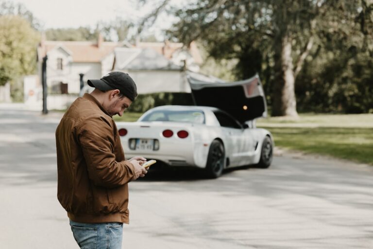 a man standing in the street looking at his cell phone