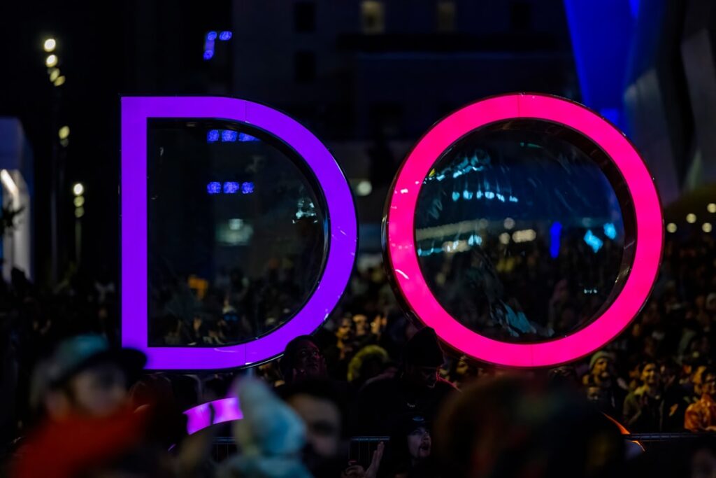 a crowd of people standing around a big sign