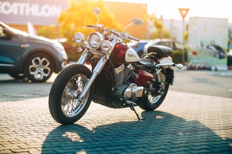 Vintage motorcycle parked in urban setting during sunset, showcasing classic aesthetic.