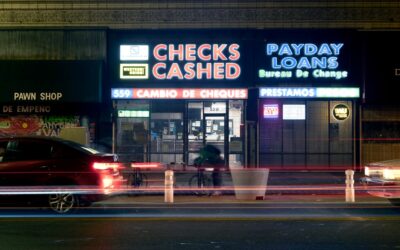 Neon signs for check cashing and payday loans at night