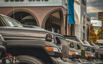 a row of parked cars in front of a used car store