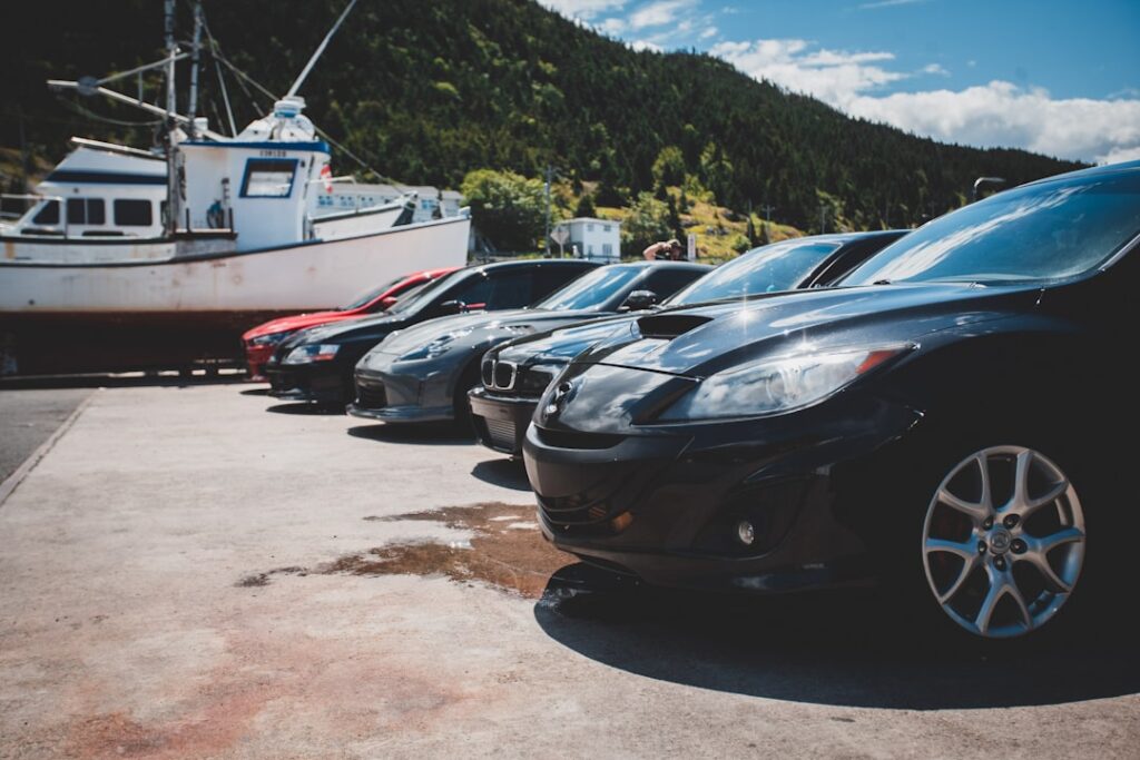 a group of cars parked next to a boat