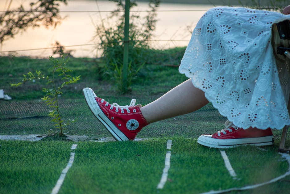 Lacy white dress paired with red sneakers in a serene outdoor setting during sunset.