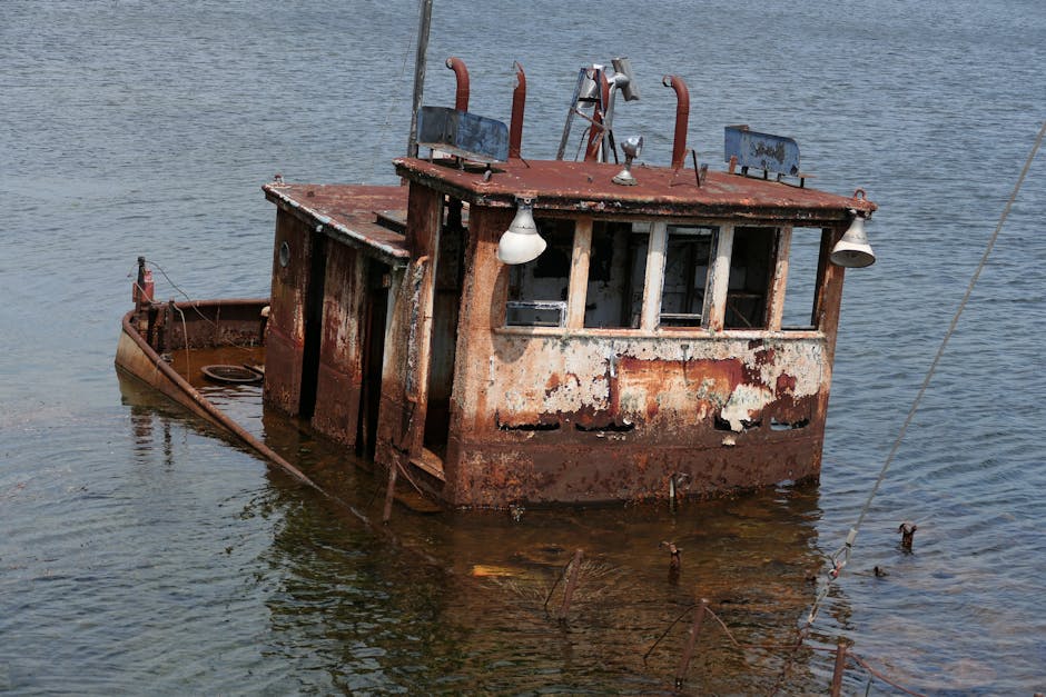 Abandoned rusty boat partially submerged in a calm lake setting at The Villages, Florida.