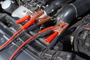 Jumper cable clamps attached in a car engine bay