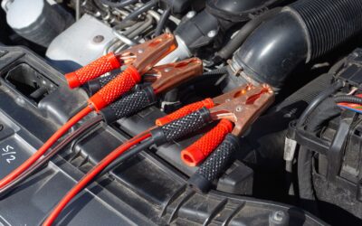 Jumper cable clamps attached in a car engine bay