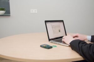 Person using a laptop at a table to pay a bill